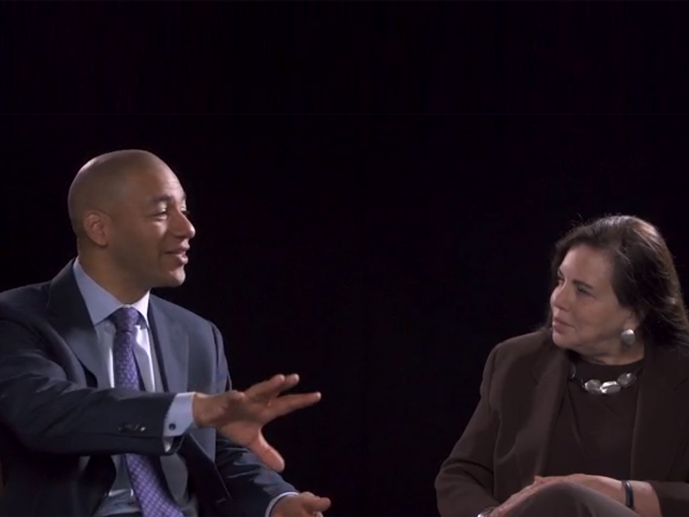 A man and a woman sit next to each other and talk