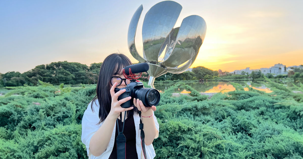 A student photographing a lush landscape.