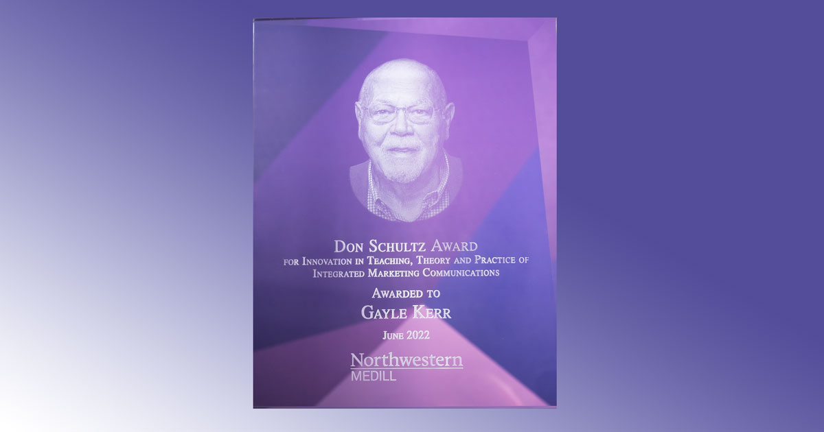 A transparent plaque featuring an image of Don Schultz. The text reads: Don Schultz Award for Innovation in Teaching, Theory and Practice of Integrated Marketing Communications Awarded to Gayle Kerr June 2022 Northwestern Medill.