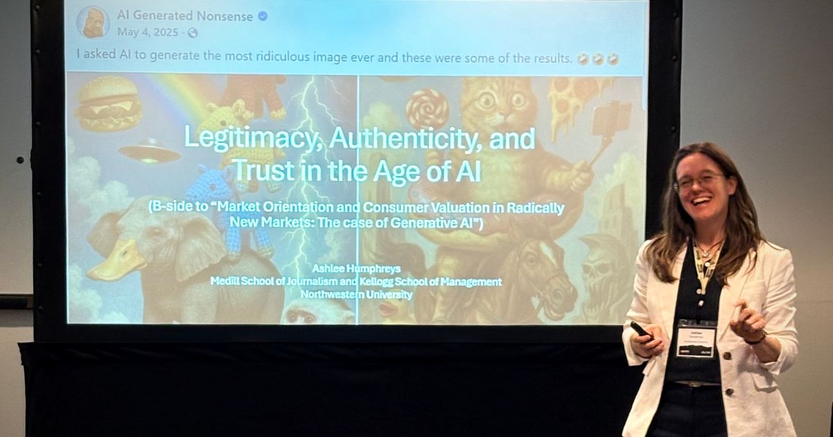 Smiling researcher presents beside a projected slide titled “Legitimacy, Authenticity, and Trust in the Age of AI,” with whimsical images.