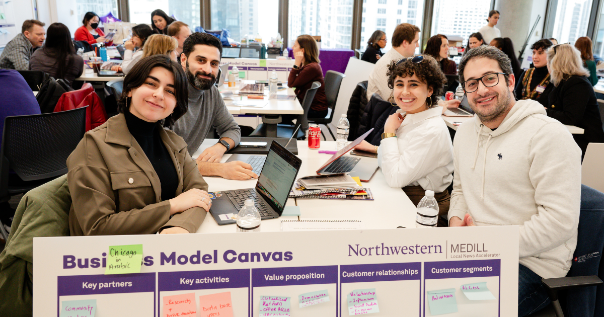 Students smiling around a table.