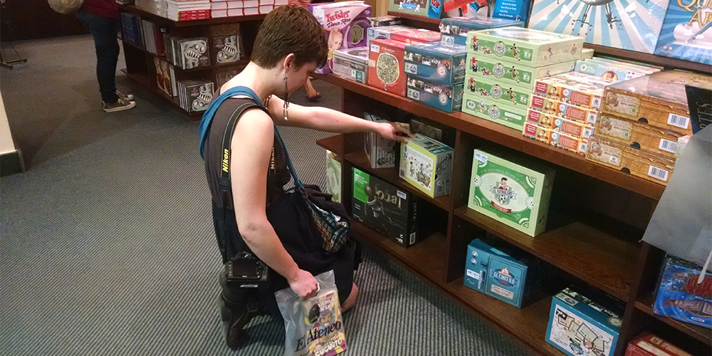 MSJ student explores board game selection in the El Ateneo bookstore.