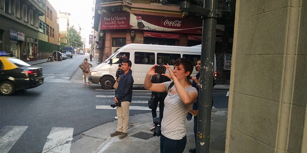 Ceci Rodgers and several students stop to photograph a mural.