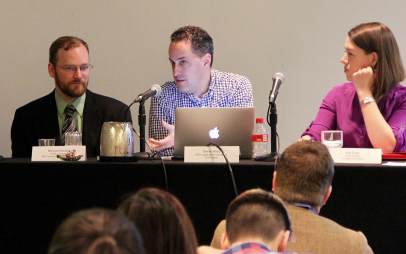 Panelists speaking at an event.