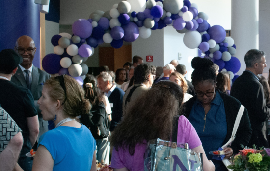 Alumnus and Dean Charles talking in a group