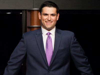 A Medill student in a suit and purple tie.