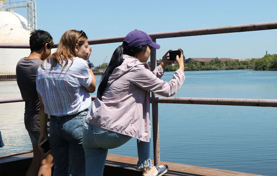 Students take photos of a lake.